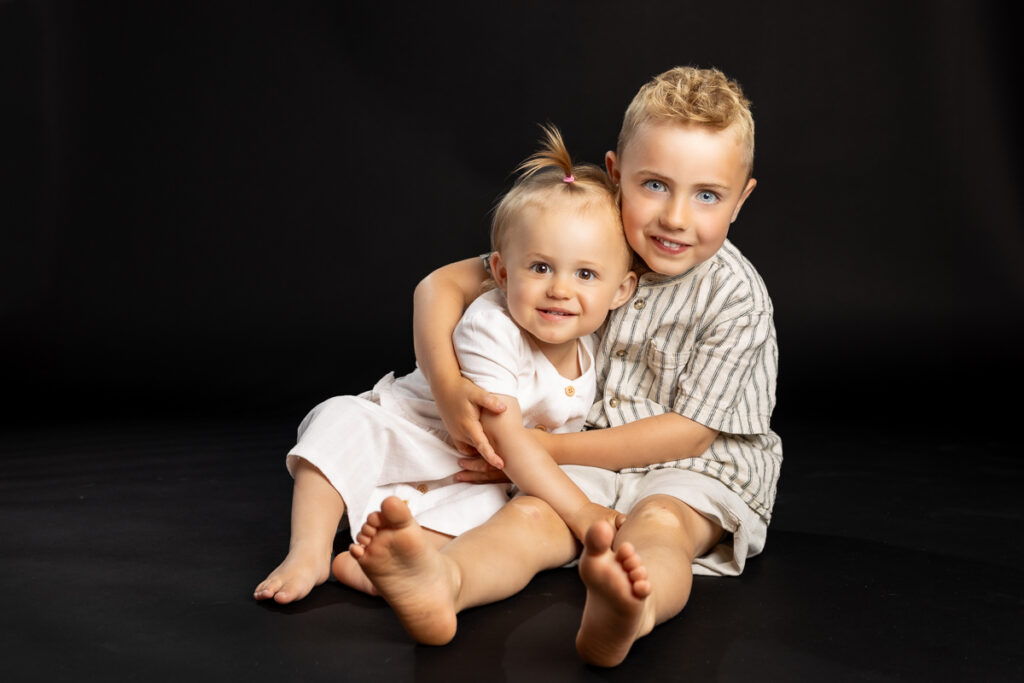 skolefotografering i studiet hos Winther sol foto, på sort baggrund. søskende